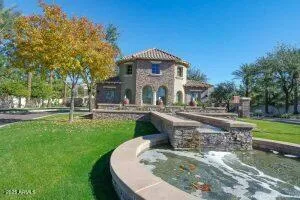 a front view of a house with garden and trees