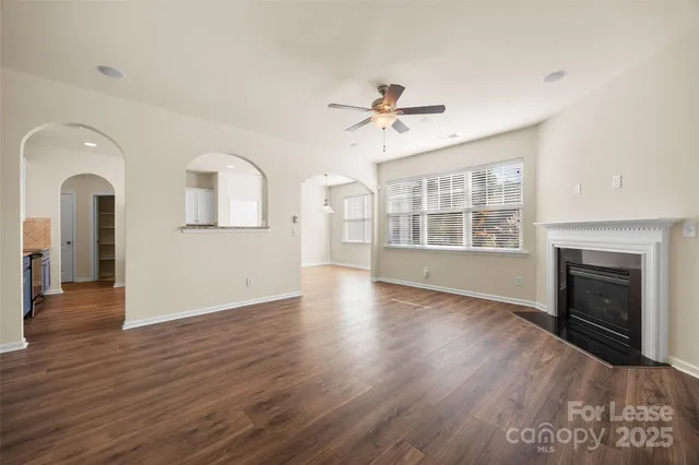 a view of an empty room with a fireplace and wooden floor