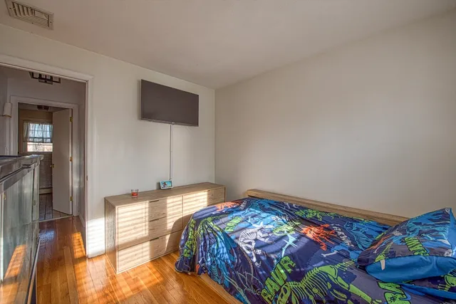 a bedroom with a bed and a lamp on the dresser