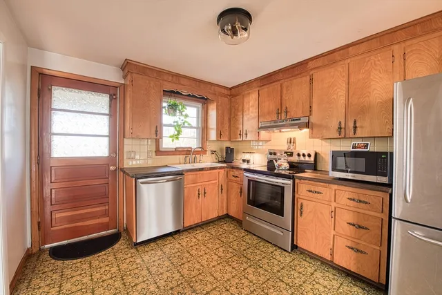 a kitchen with stainless steel appliances granite countertop a stove a sink and a refrigerator