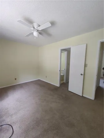 an empty room with a ceiling fan and a window