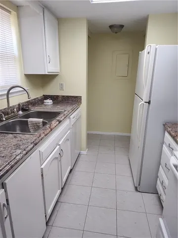a kitchen with a sink a refrigerator and cabinets