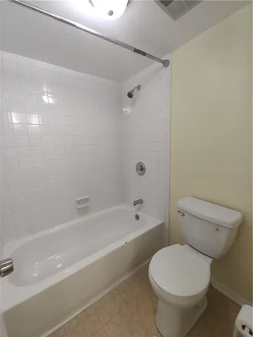 a white toilet and tub sitting next to a bathroom sink