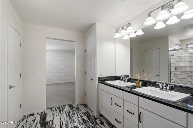 a bathroom with a sink a light fixture and a mirror