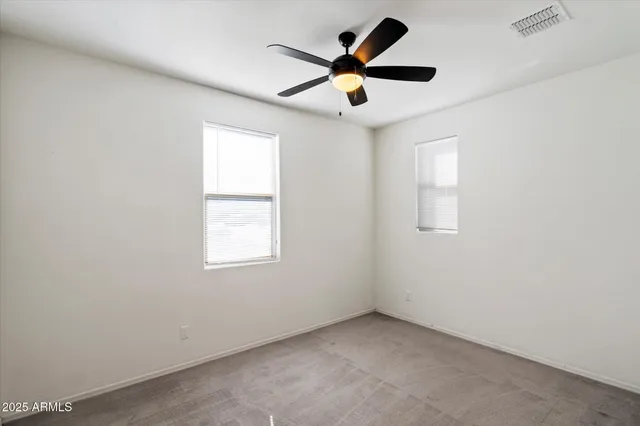 an empty room with a window and a fan