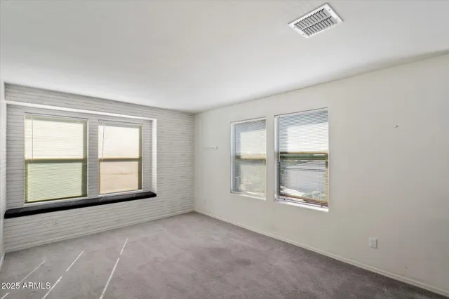 an empty room with windows and closet