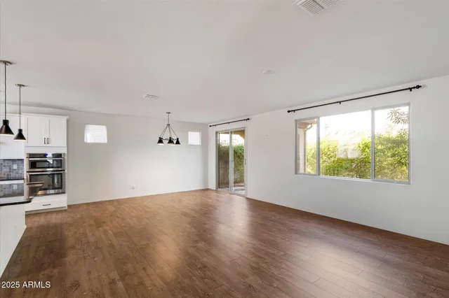 a view of a kitchen with wooden floor and windows