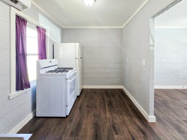 a kitchen with wooden floors and white appliances