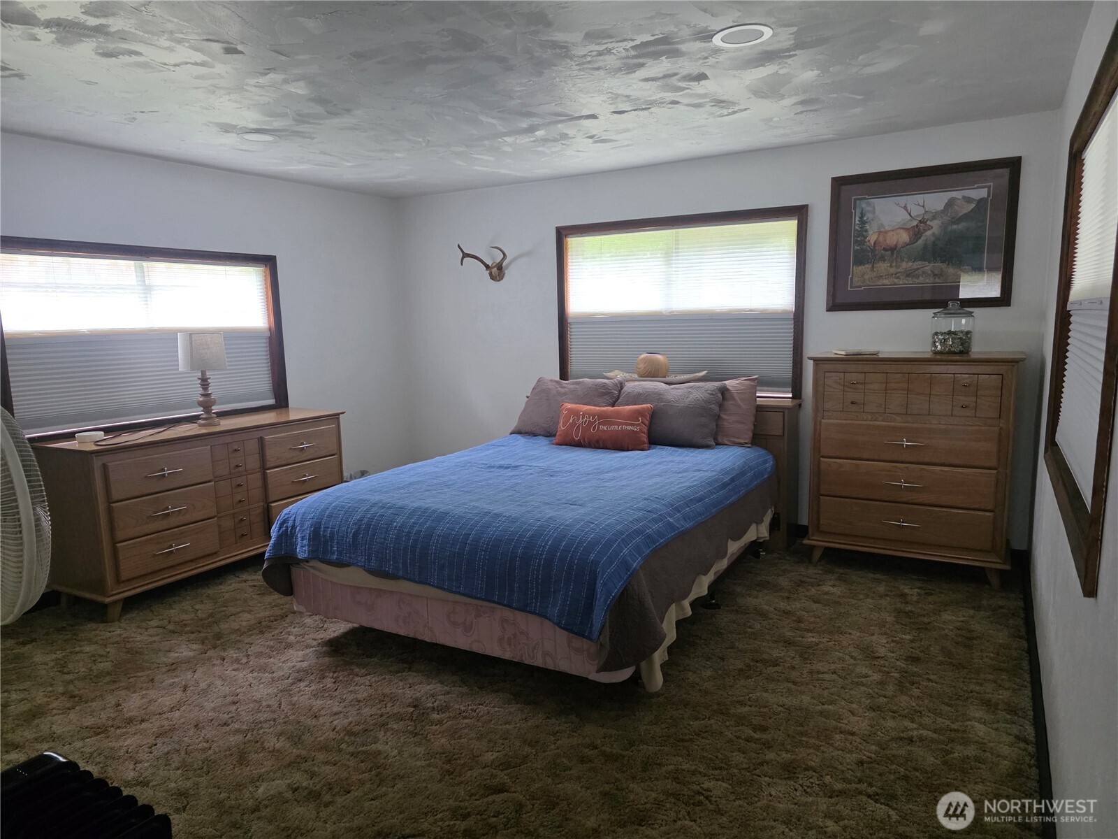 540 Nichols Road Clallam Bay, WA 98326 - Photo 12 of 25 a spacious bedroom with a bed and a dresser in it