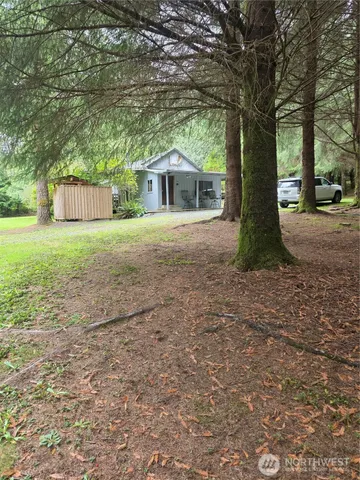 a white house that has a tree in front of it