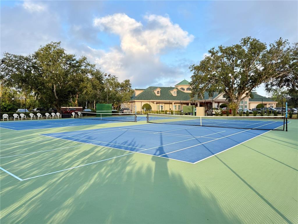 9500 Green Needle Drive New Port Richey, FL 34655 - Photo 22 of 28 a tennis court with view of trees in the background