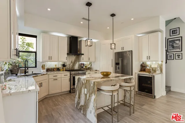 a kitchen with stainless steel appliances granite countertop a stove a refrigerator a oven a sink with a dining table and chairs