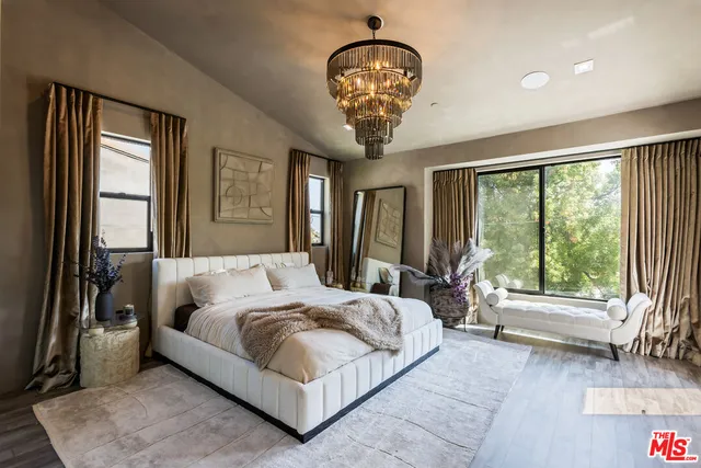 a bedroom with a large bed and a chandelier