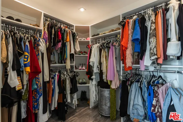 a view of walk in closet with clothes