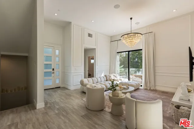 a room with a chandelier and wooden floor