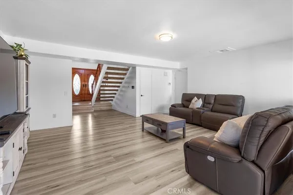 a living room with furniture and a wooden floor