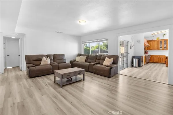 a kitchen with stainless steel appliances granite countertop a dining table chairs stove and cabinets