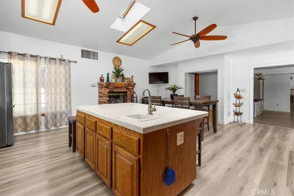 a kitchen with stainless steel appliances a sink dishwasher a stove a refrigerator and cabinets with wooden floor
