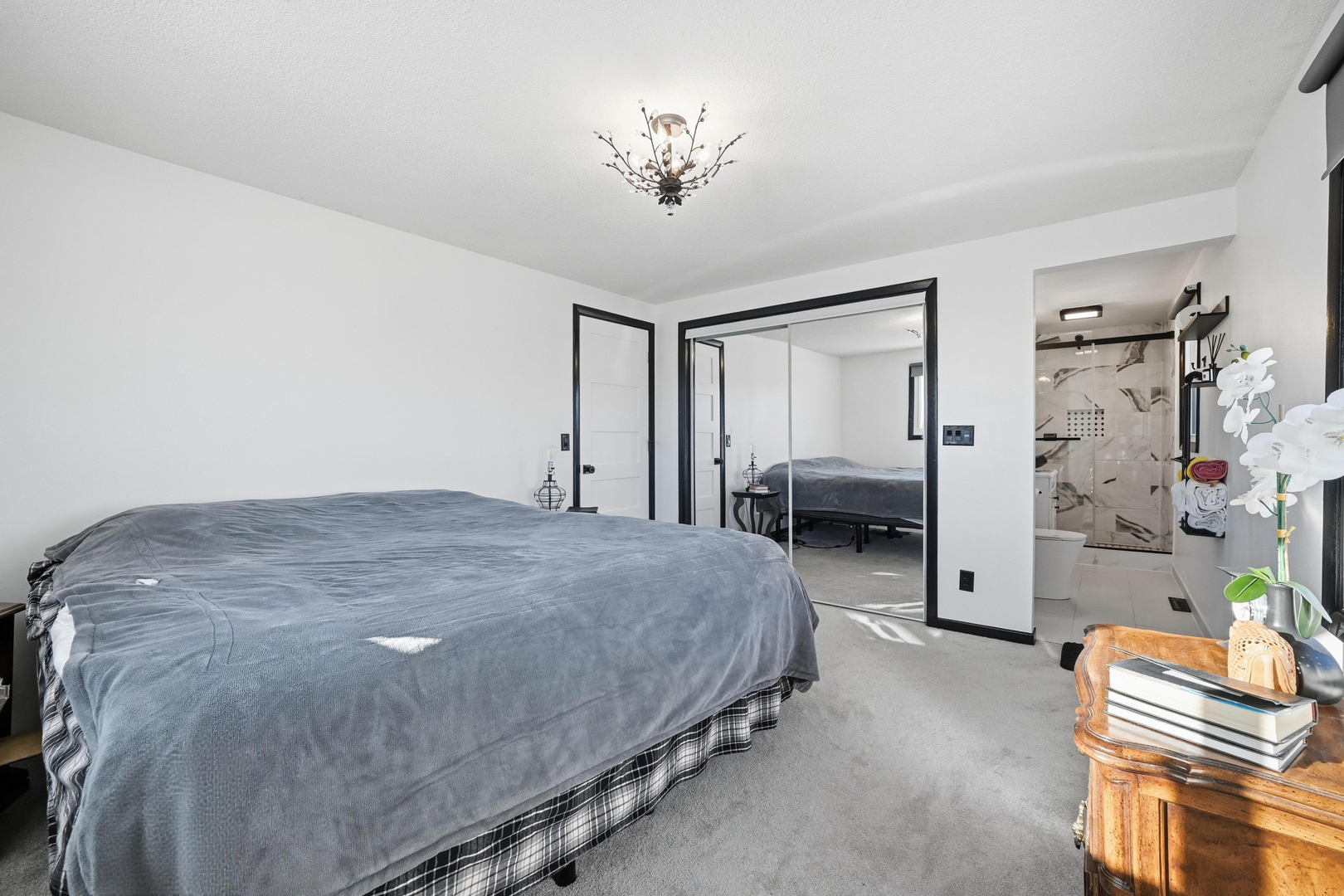 9807 North Leaf River Road Leaf River, IL 61047 - Photo 15 of 38 a spacious bedroom with a bed and a chandelier