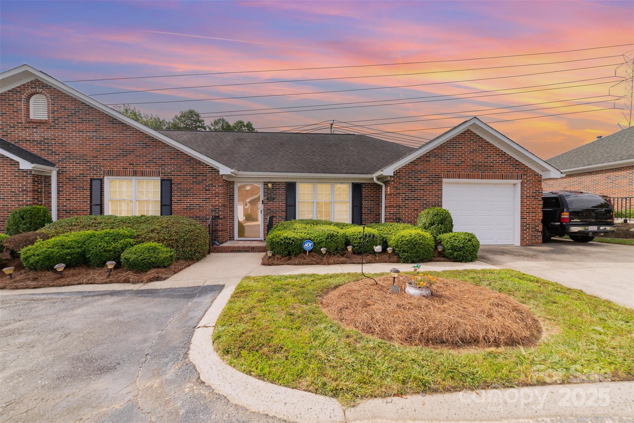 a view of a white house with a small yard and potted plants