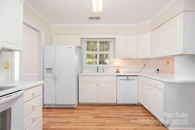 a kitchen with white cabinets and white appliances
