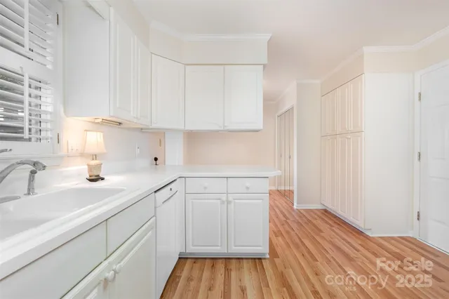 a kitchen with wooden floors and white cabinets