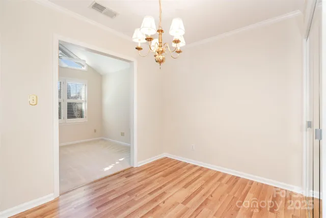 a kitchen with stainless steel appliances granite countertop a refrigerator a sink dishwasher and white cabinets with wooden floor