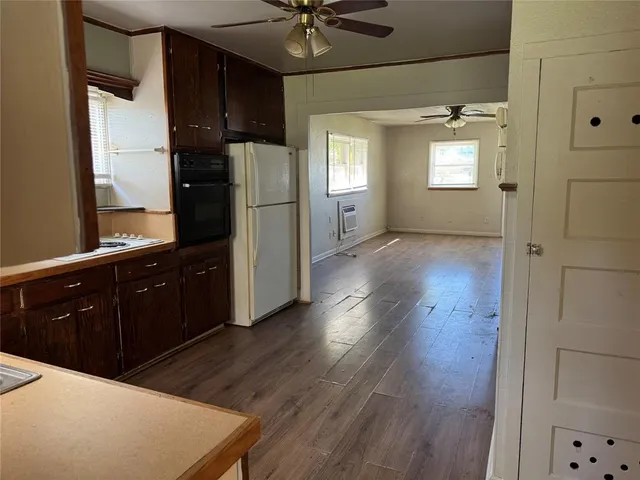 a kitchen with granite countertop a refrigerator a sink and dishwasher