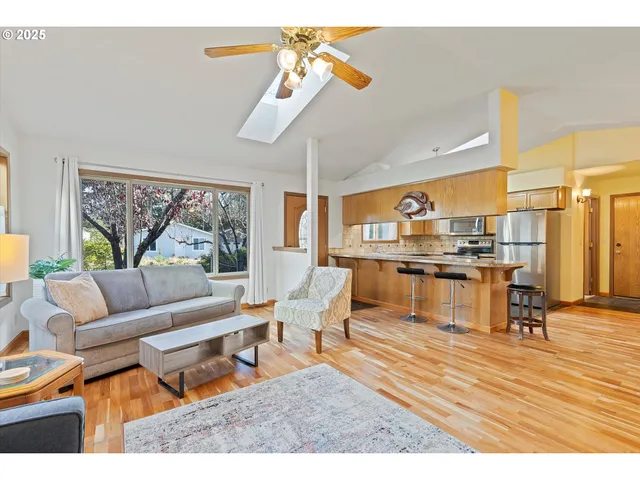 a living room with couches a coffee table and a dining table with wooden floor