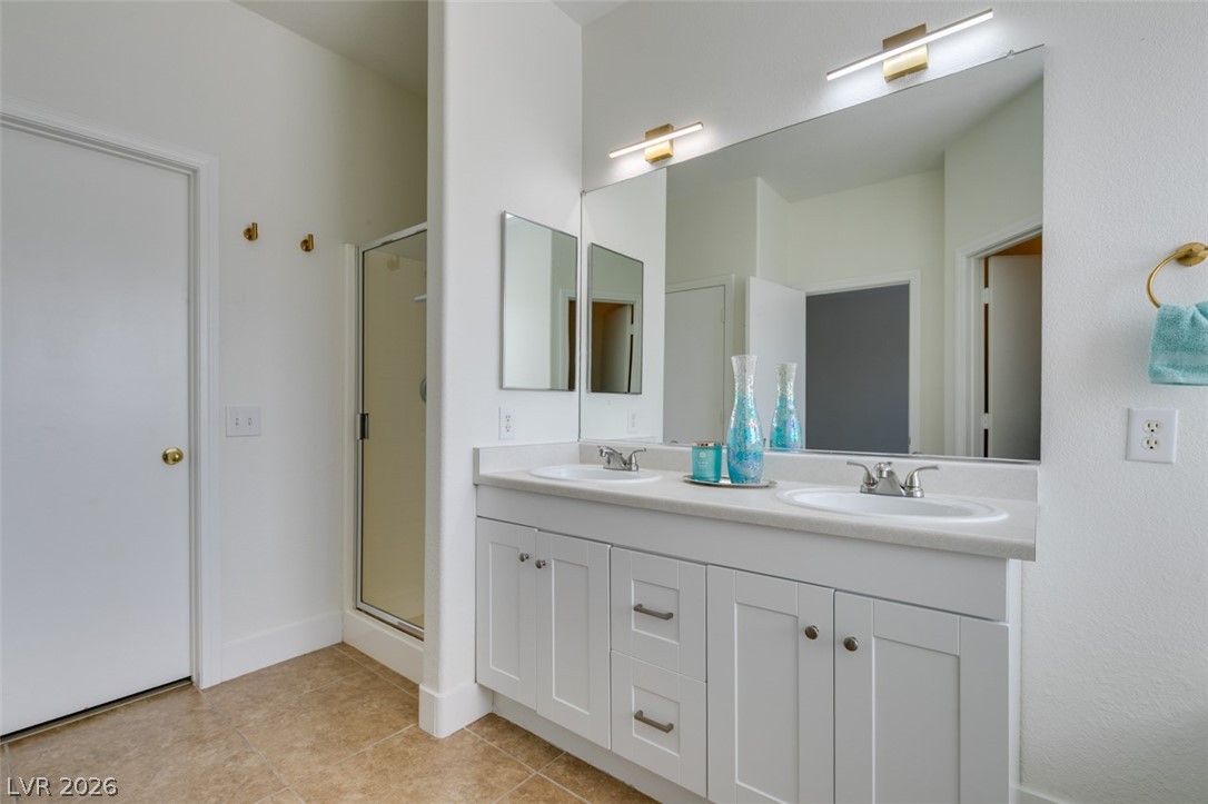 10959 Pumpkin Ridge Avenue Las Vegas, NV 89135 - Photo 27 of 51 Dual vanity with clean white cabinetry and a glass-enclosed shower await in this magnificent bathroom.