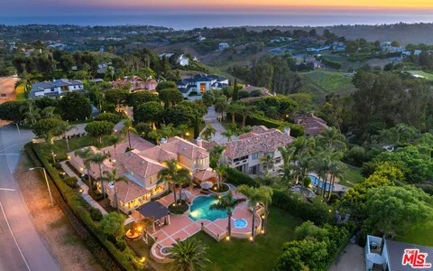 a front view of a house with garden and swimming pool