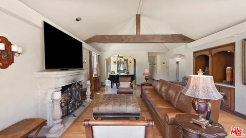 a living room with furniture a rug and a floor to ceiling window