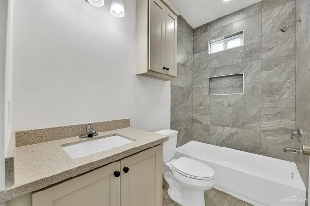 an empty room with wooden floor closet and windows