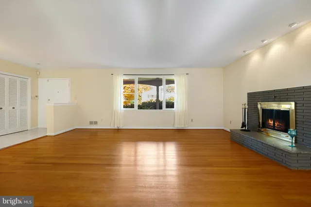 a view of an empty room with a fireplace and a window