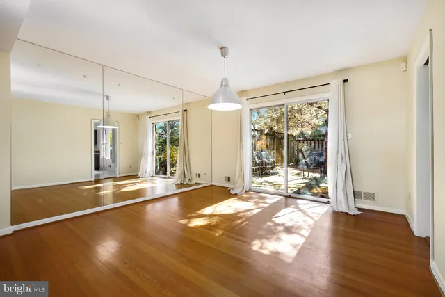 a view of a livingroom with wooden floor and a ceiling fan