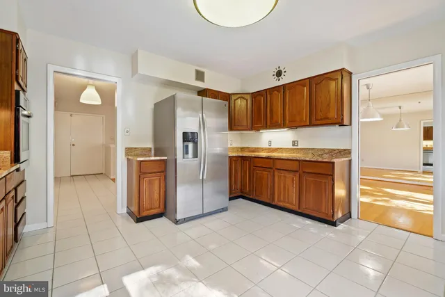 a kitchen with stainless steel appliances granite countertop a stove a refrigerator and a cabinets