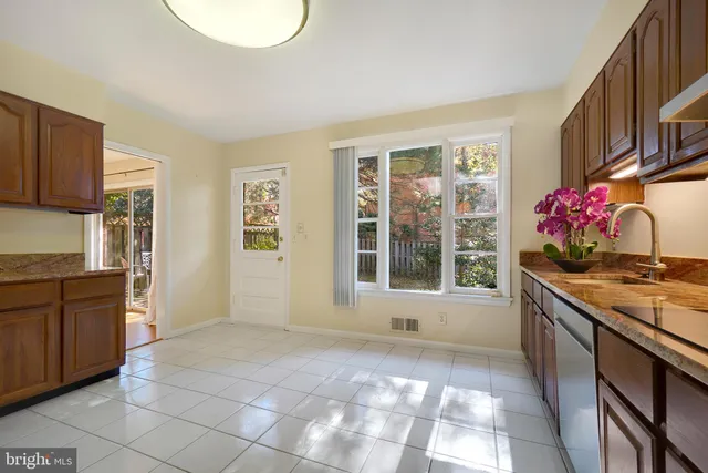 a kitchen with granite countertop a stove a sink and a refrigerator