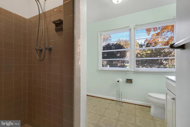 a bathroom with a window a toilet and a shower