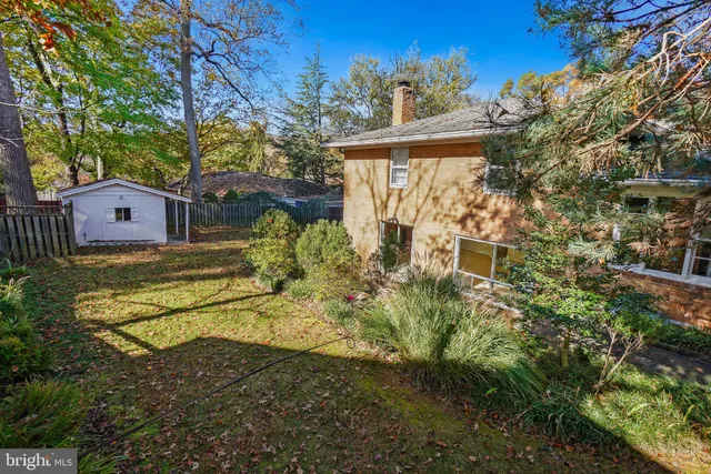 a view of a house with a big yard and large trees