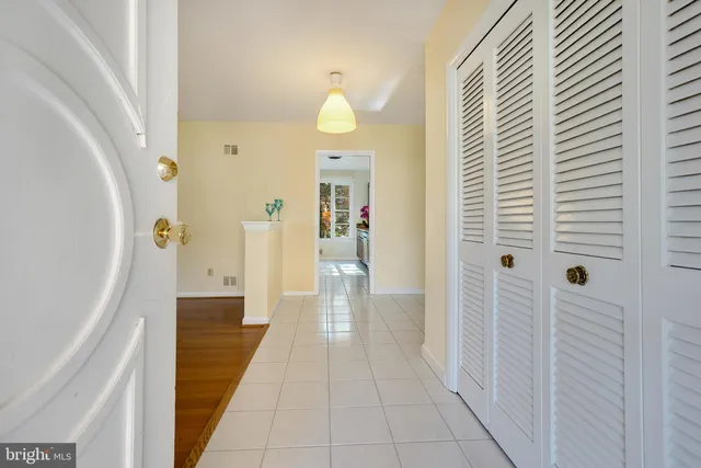 a view of a hallway with wooden floor and a bathroom