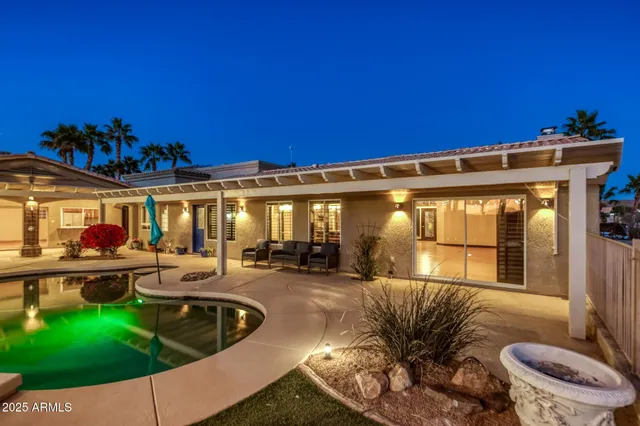 a large kitchen with stainless steel appliances kitchen island granite countertop a refrigerator a stove a sink dishwasher with a dining table and chairs with wooden floor