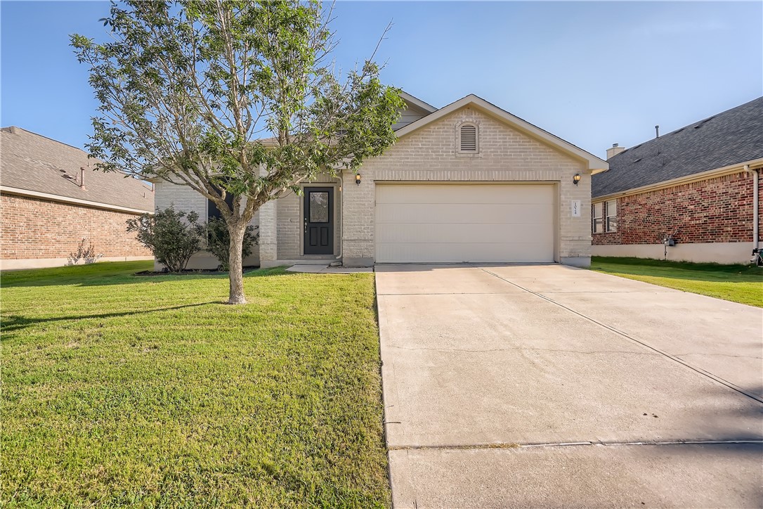 a front view of house with yard and trees