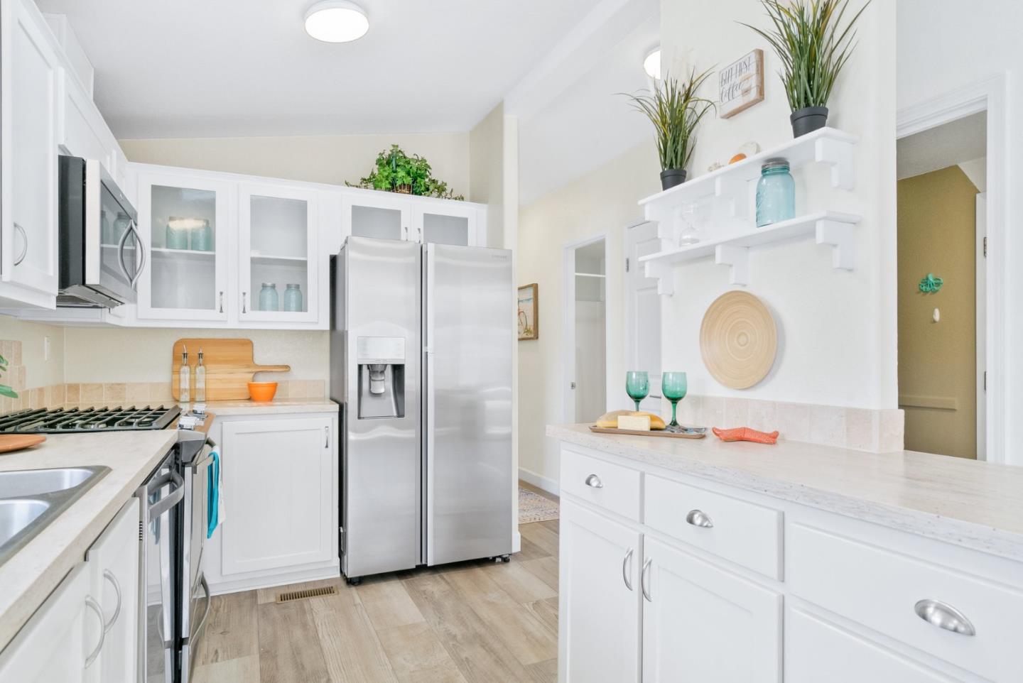 100 North Rodeo Gulch Road, Unit 65 Soquel, CA 95073 - Photo 12 of 33 a kitchen with stainless steel appliances a white refrigerator a oven a stove and a wooden floors