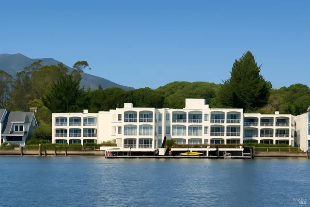 a view of a large pool with lawn chairs and a yard