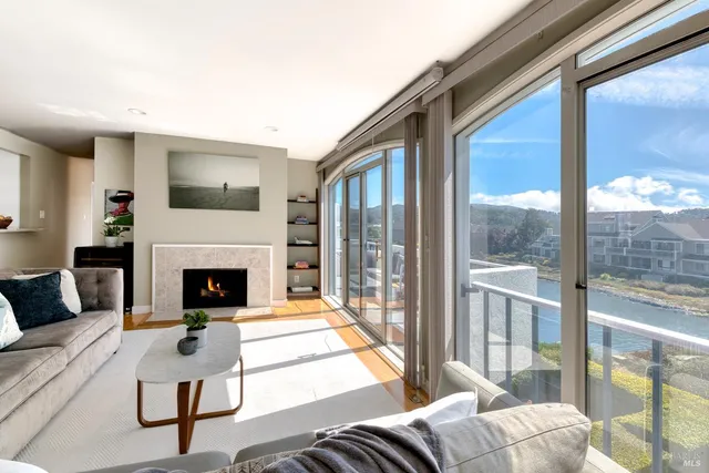 a living room with furniture a large window and a fireplace