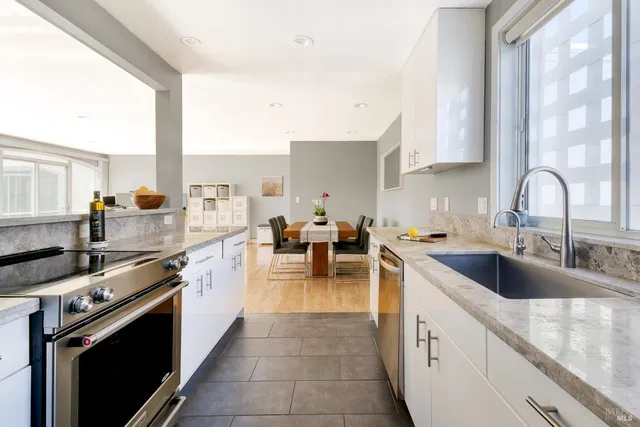 a large kitchen with stainless steel appliances granite countertop a lot of counter space and a sink