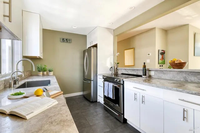 a kitchen with stainless steel appliances granite countertop a sink stove and refrigerator