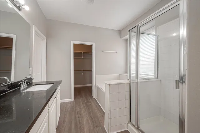a bathroom with a granite countertop sink tub and a mirror