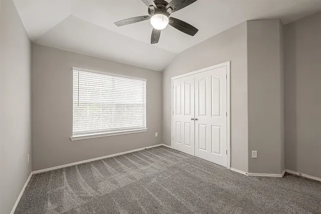 an empty room with chandelier fan