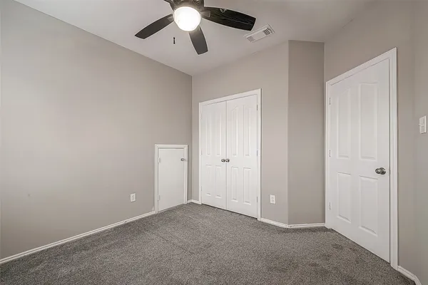an empty room with a window and a fan